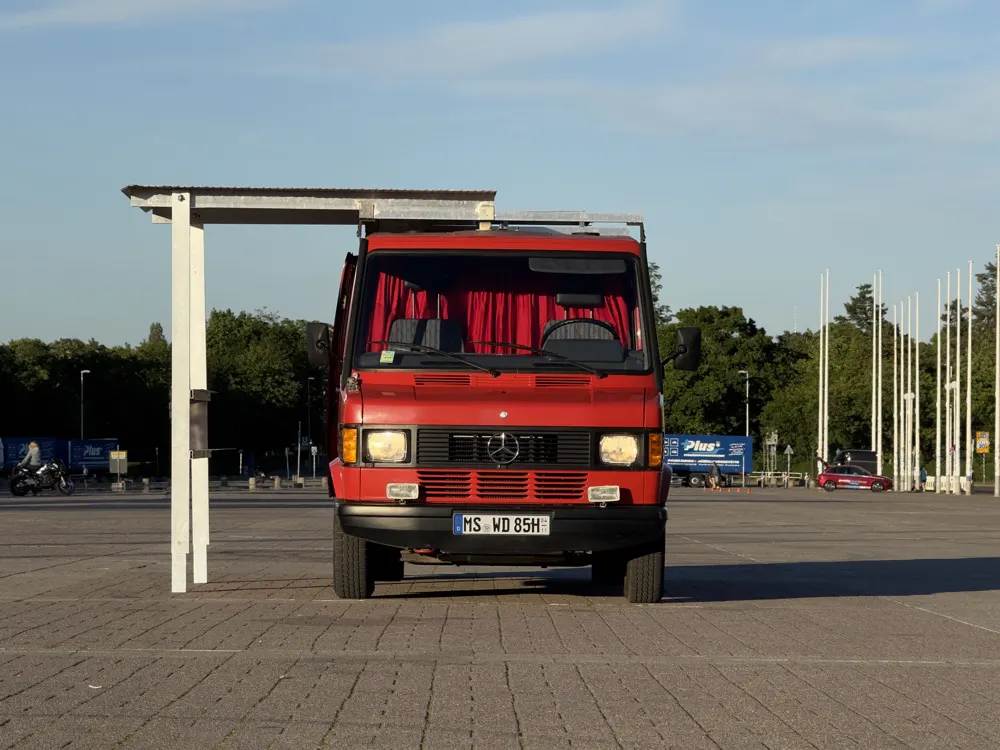 Der rote Bombero-Wagen von vorn auf einem weiten Platz