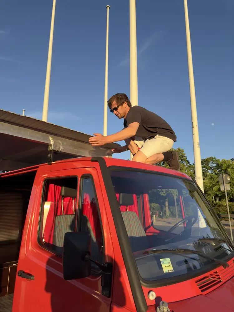 Ein Teammitglied auf dem Dach des Wagens
