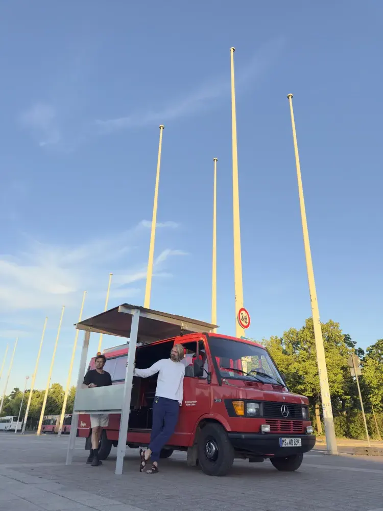 Fahnenmasten vor blauem Himmel mit dem Wagen im Vordergrund